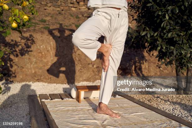 faceless man standing in tree pose during yoga session - bare feet male tree stock pictures, royalty-free photos & images