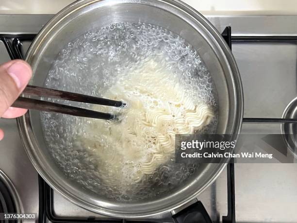 instant noodles over boiling water - boiling pasta stock pictures, royalty-free photos & images