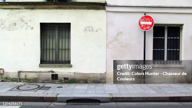 wall of weathered buildings with sidewalk and street without people in paris - rinnstein stock-fotos und bilder