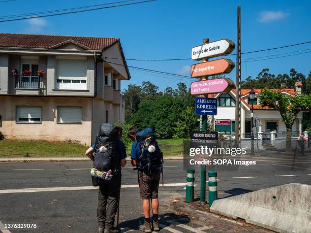 Two pilgrims are seen checking the route on their mobile phones on the Camino de Santiago pilgrimage route. The Camino de Santiago is a large network...