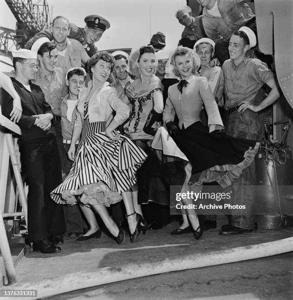 From left to right, actresses Betty Garrett, Ann Miller and Vera-Ellen pose with a group of men during the filming of the movie 'On The Town' in New...