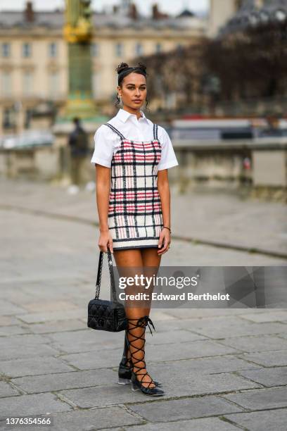 Guest wears a gold and rhinestones earring from Dior, earrings, a white shirt, a white with red and black checkered print pattern tank-top short...