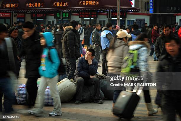 Chinese migrant workers wait to board their train home for the annual Chinese New Year holidays, at the Beijing Train Station on January 15 2012. The...