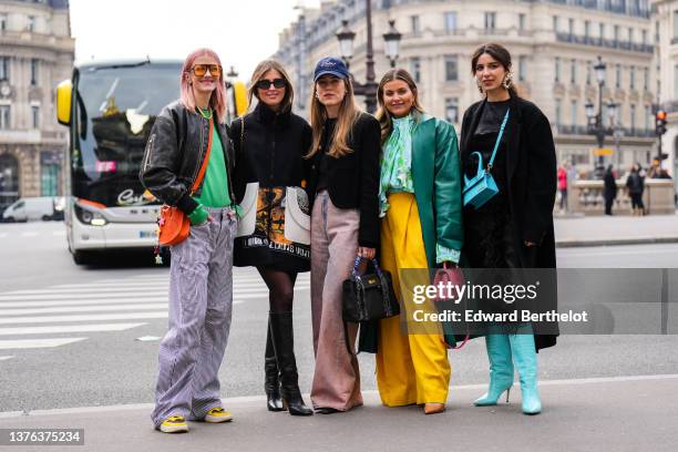 Marianne Theodorsen wears orange sunglasses, gold and silver chain pendant necklace, a yellow and green pearls necklace, a blue t-shirt, a green wool...