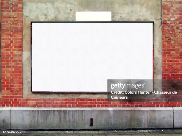 empty billboard on a weathered wall and sidewalk in brussels - poster wall stock-fotos und bilder