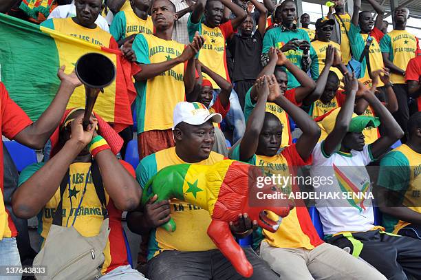 Supporters of the Senegal National football team, dubbed the Lions of the Teranga, cheer with a plastic lion painted in the country's colours, during...