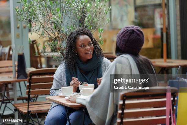 mother and daughter talking and enjoying lunch at cafe patio table - sidewalk cafe stock pictures, royalty-free photos & images