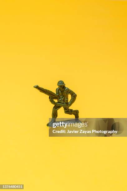 war toys on yellow background. soldier. - mercenary human role stock-fotos und bilder