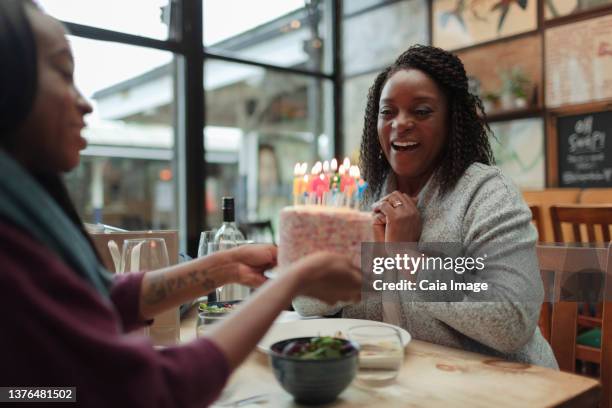 happy mother and daughter celebrating birthday with cake in cafe - older woman birthday stock pictures, royalty-free photos & images