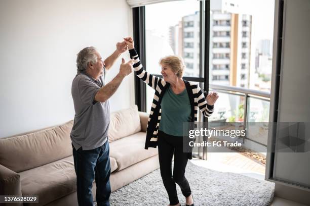 happy senior couple dancing at home - fun lovers unite stock pictures, royalty-free photos & images