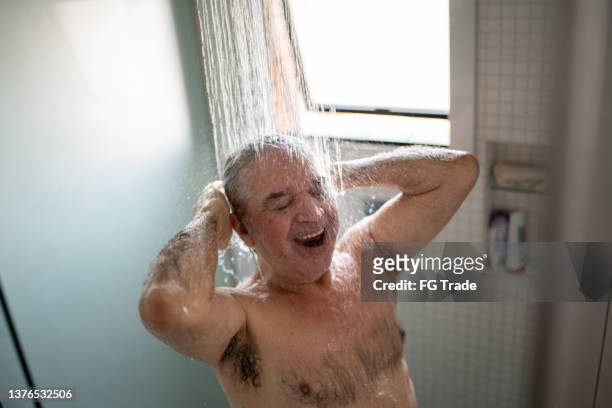 happy senior man taking a shower at home - men taking a shower stockfoto's en -beelden