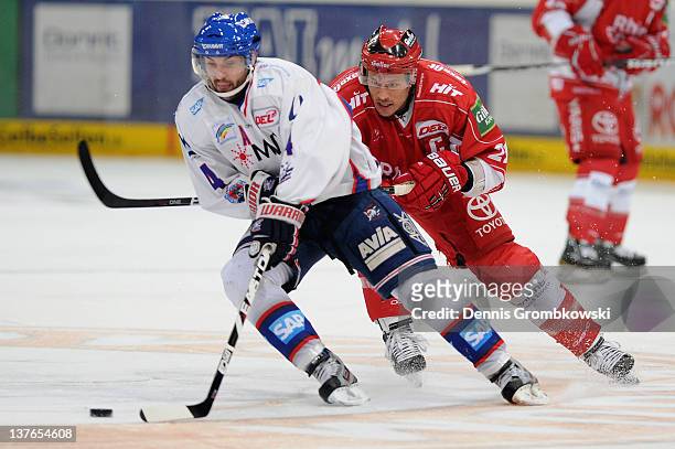 Christopher Lee of Mannheim is chased by John Tripp of Cologne during the DEL match between Koelner Haie and Adler Mannheim at Lanxess Arena on...