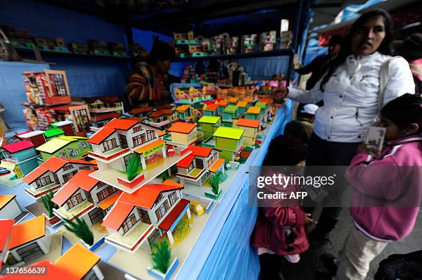 Miniature houses are seen during the Alasitas --"buy from me" in native language-- festival to honor the Ekeko, the Aymara God of Abundance, on...