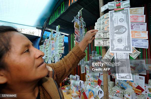 An Aymara native woman sells notes during the Alasitas --"buy from me" in native language-- festival to honor the Ekeko, the Aymara God of Abundance,...