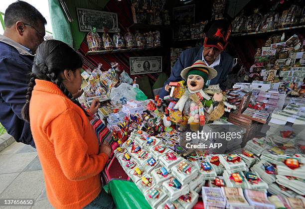 People buy notes at a stand during the Alasitas --"buy from me" in native language-- festival to honor the Ekeko, the Aymara God of Abundance, on...