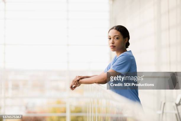 serious, exhausted female surgeon turns to look at camera - real life science stock pictures, royalty-free photos & images