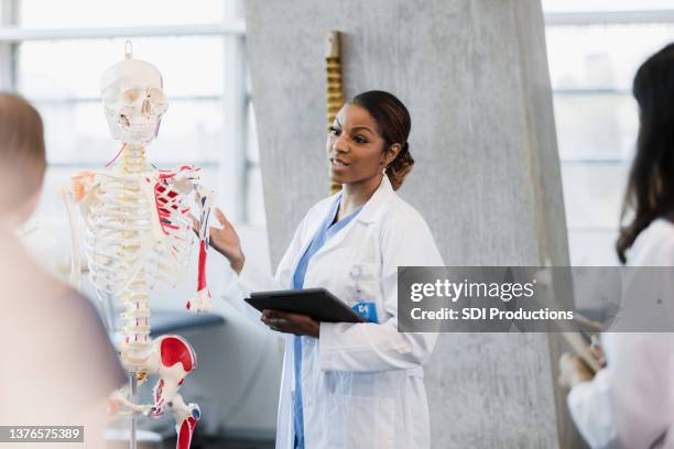 visiting lecturer teaches class on human skeletal system - human skeletal system stockfoto's en -beelden