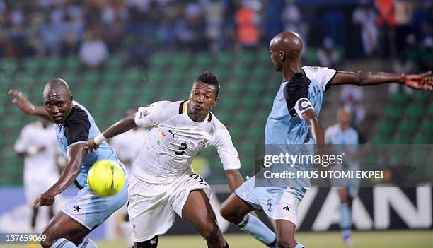 Ghana's striker Asamoah Gyan tries to dribble past Botswana's midfielder Mompati Thuma and defender Ndiyapo Letsholathebe during an African Cup of...