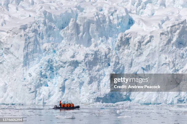 tourists are taking a boat cruise in antarctica. - antarctica boat stock pictures, royalty-free photos & images