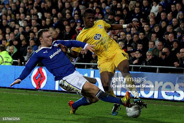 Wilfried Zaha of Crystal Palace is tackled by Darcy Blake of Cardiff City during the Carling Cup Semi Final second leg match between Cardiff City and...