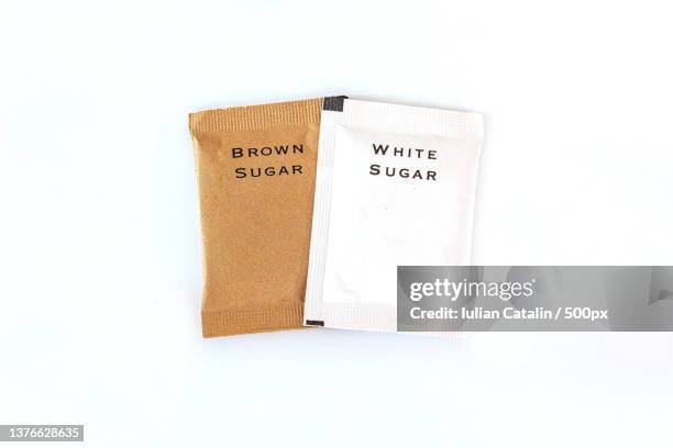 top down view of white and brown sugar bag against white background - sachet stock pictures, royalty-free photos & images