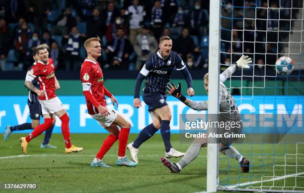 Sebastian Polter of VfL Bochum scores their team's first goal past Mark Flekken of SC Freiburg during the DFB Cup quarter final match between VfL...