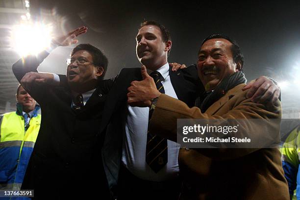 Malky Mackay the Cardiff City manager celebrates with club owner Tan Sri Vincent Tan Chee Yioun and chairman Chan Tien Ghee following his team's 3-1...