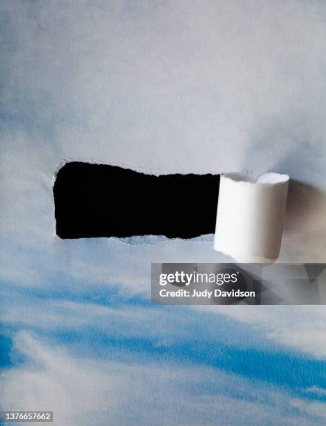 creative image of cloudy sky superimposed on torn paper - digital composite stock pictures, royalty-free photos & images