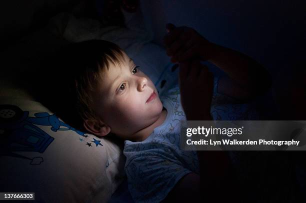 boy playing with ipod in bed - boy ipod bildbanksfoton och bilder