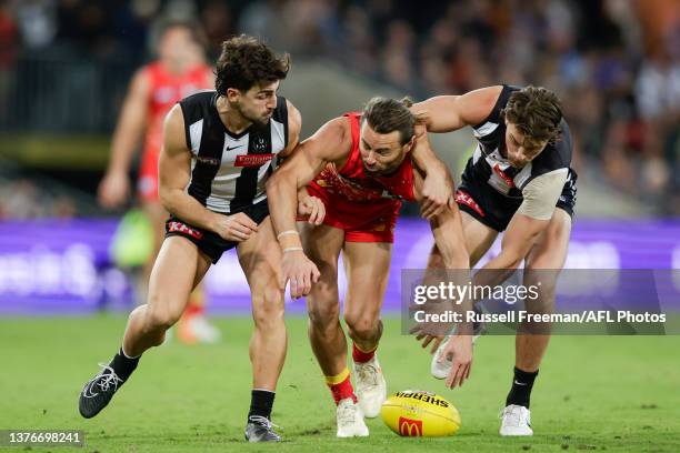 Josh Daicos and Patrick Lipinski of the Magpies compete with Lachie Weller of the Suns for the ball during the 2023 AFL Round 16 match between the...