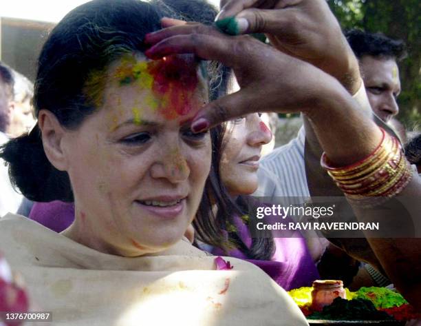 Indian Opposition leader and Congress Party President Sonia Gandhi has coloured powder applied to her forehead during celebrations for 'Holi' at her...