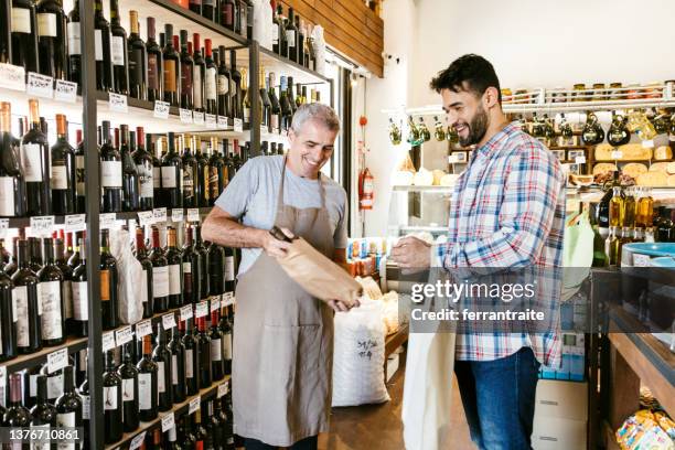 vintner talking to customer - wine rack stock pictures, royalty-free photos & images