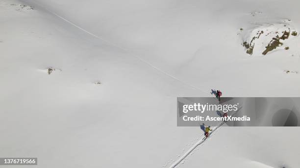 aerial view of ski mountaineers moving up a slope - mountaineering team stock pictures, royalty-free photos & images