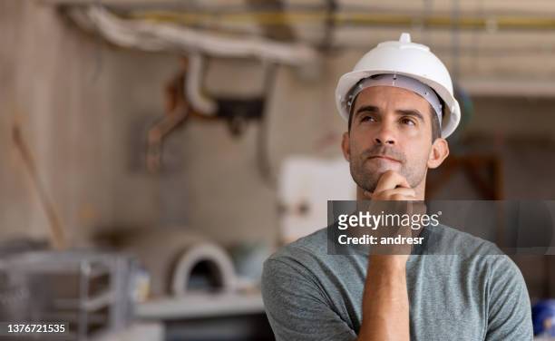 man building a house and looking thoughtful at the construction site - only mature men imagens e fotografias de stock