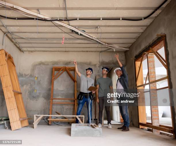 groupe de travailleurs travaillant sur le câblage électrique d’une maison en construction - professional occupation photos et images de collection