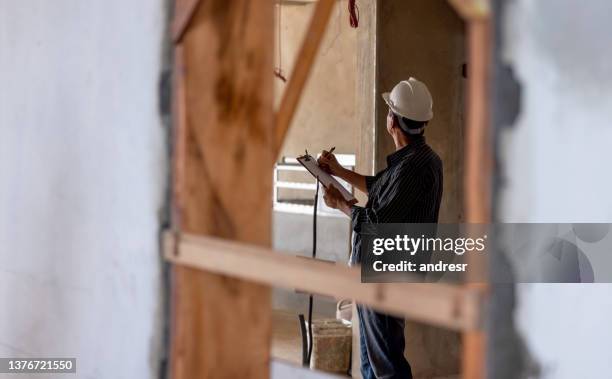 bauarbeiter, der die entwicklung einer baustelle überwacht - rebuilding stock-fotos und bilder