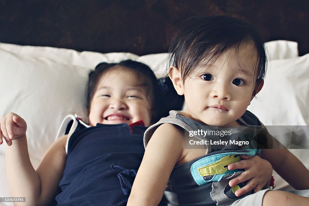 Little kids having fun on bed