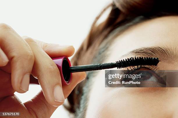 young woman applying eyelash makeup, close-up - applying mascara stock-fotos und bilder