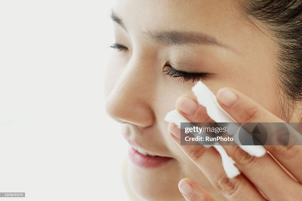 Young woman applying lotion