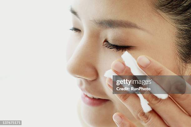 young woman applying lotion - cotton pad stock pictures, royalty-free photos & images