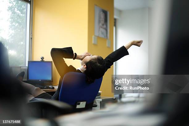 businesswoman yawning in the office - tired ストックフォトと画像