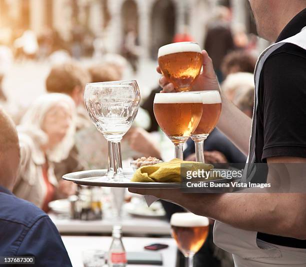 waiter serving beer in brussels - brussels stock pictures, royalty-free photos & images