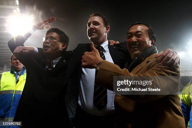 Malky Mackay the Cardiff City manager celebrates with club owner Tan Sri Vincent Tan Chee Yioun and chairman Chan Tien Ghee following his team's 3-1...