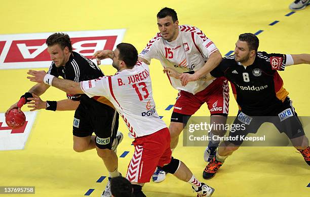 Bartosz Jurecki pol and Michal Jurecki of Poland defend against Lars Kaufmann of Germany and Christoph Theuerkauf of Germany during the Men's...