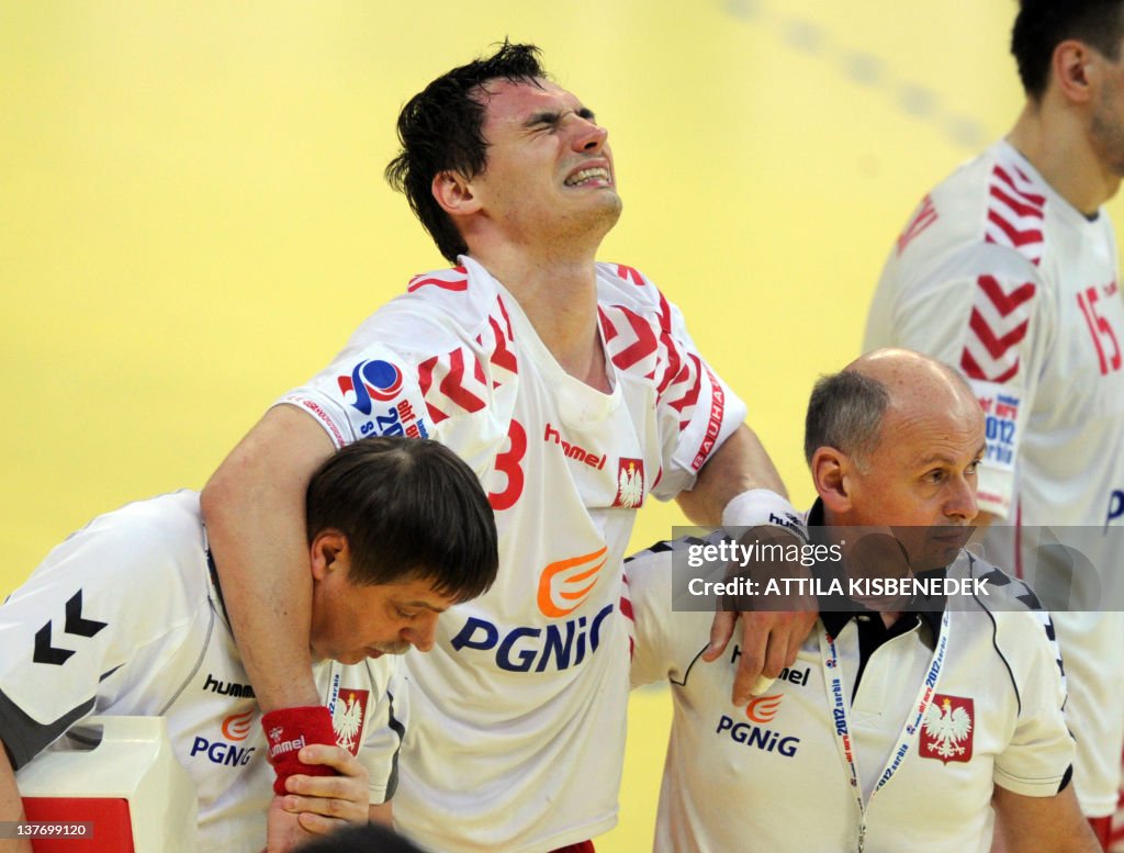 Polish Krzysztof Lijewski (C)  is helped