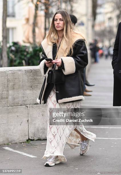 Guest is seen wearing a black faux fur collared jacket and Cecilie Bahnsen white dress outside Rochas show during Paris Fashion Week A/W 2022 on...