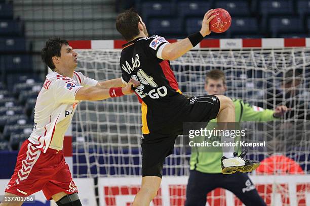 Krzysztof Lijewski of Poland defends against Michael Haass of Germany during the Men's European Handball Championship second round group one match...