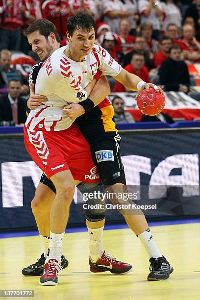 Michael Haass of Germany defends against Krzysztof Lijewski of Poland during the Men's European Handball Championship second round group one match...