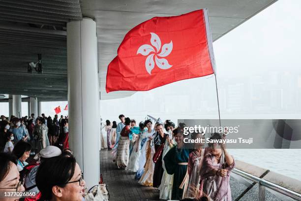 People wave Hong Kong flag during the 26th handover anniversary on July 1, 2023 in Hong Kong, China. Hong Kong is marking the 26th anniversary of its...