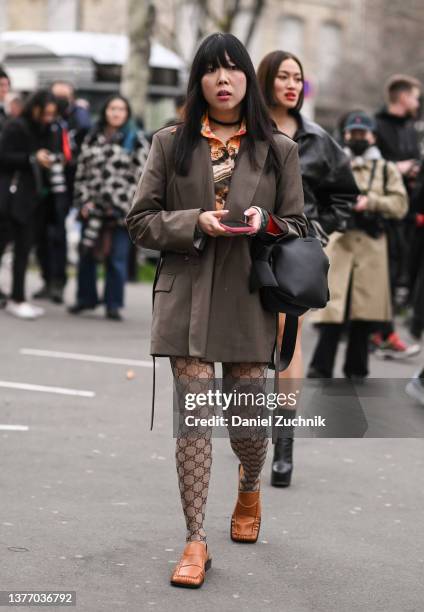 Susie Lau is seen wearing a brown blazer and Gucci stockings and Gucci shoes outside the Cecilie Bahnsen show during Paris Fashion Week A/W 2022 on...